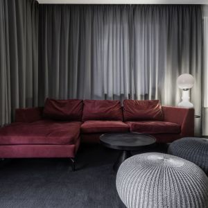 Sofa w kolorze burgundowym zajmuje główne miejsce w salonie. Projekt wnętrza: Daria Wiergowska, Hatch Studio. Zdjęcia: XS Studio Małgosia Bartnik