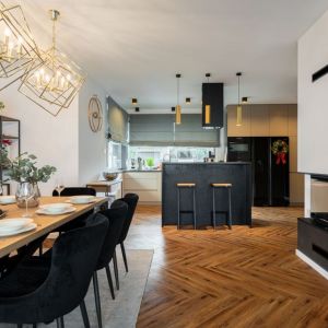 Jasne kolory i kominek w nowoczesnym salonie z kuchnią. Projekt wnętrza: Aleksandra Michalak, Dekorian Home. Fot. Łukasz Michalak