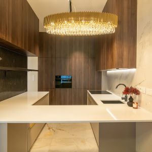 Nowoczesna kuchnia z meblami w kolorze drewna. Projekt i nadzór autorski: archdesign Agnieszka Romańczyk. Zdjęcia: Adam Kocimski Fotografia
