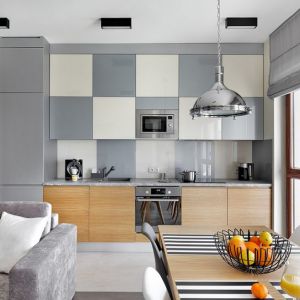 Biel, szarości i drewno w małej kuchni z salonem. Projekt wnętrza: Katarzyna Rohde, pracownia HOME & STYLE. Zdjęcie: Bernard Białorucki