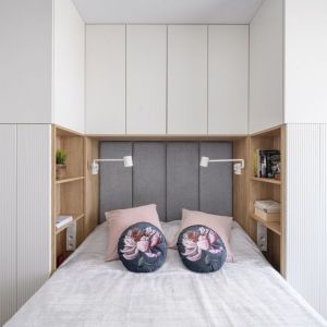 Kolor biały i jasne drewno w małej sypialni. Projekt wnętrza: MiskiewiczDesign. Zdjęcie: Łukasz Zandecki
