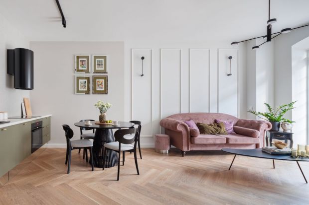 50-metrowe mieszkanie zaprojektowane jest elegancko i przytulnie. Stonowaną kolorystykę wzbogacają mocniejsze akcenty. Różowa sofa czy oliwkowa zabudowa w otoczeniu bieli, szarości i drewna prezentują się wyjątkowo i niebanalnie.<br />&