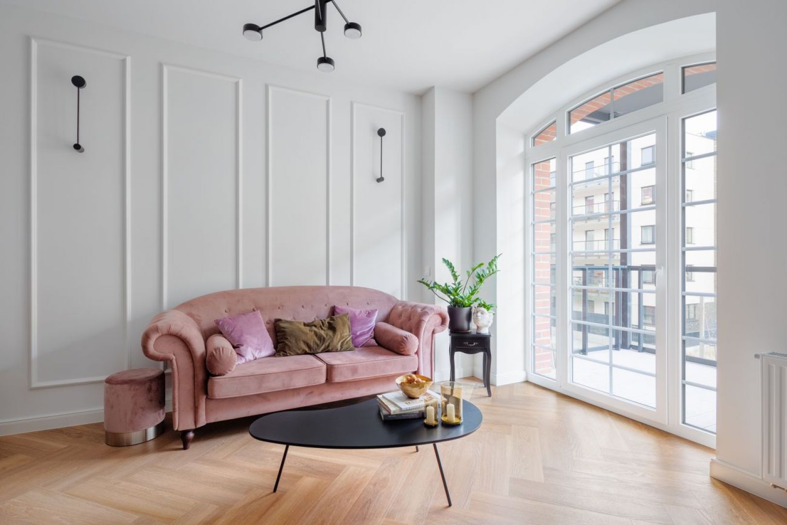 W salonie znajduje się komfortowa sofa w odcieniu brudnego różu oraz stylizowana, drewniana komoda. Projekt wnętrza: Decoroom. Fot. Marek Koptyński