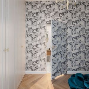 Drzwi do łazienki ukryte za dekoracyjną tapetą. Projekt wnętrza: Decoroom. Fot. Marek Koptyński