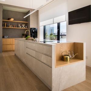 Sercem kuchni jest długa na prawie czterometrowa wyspa w całości wykończona (blat oraz fronty) spiekami. Projekt wnętrza: Natalia Teixeira, Kasia Beresińska, pracownia TK Architekci. Fot. TK Architekci