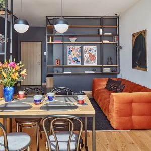 Kolor szary i biały w salonie, czarny w kuchni. Projekt wnętrza: RS Studio Projektowe, architekt Roland Stańczyk. Zdjęcie i stylizacja: Budzik Studio