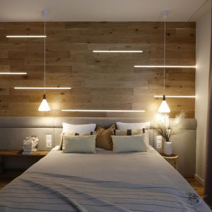 Drewno zdobiące ścianę za łóżkiem zostało podświetlone, co tworzy niezwykle ciekawą kompozycję. Projekt wnętrza i zdjęcia: Iwona Pietras, Miliform