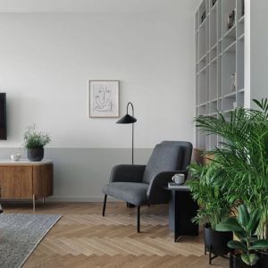 Sofa w rudym obiciu i czarne, metalowe stoliki w nowoczesnym salonie w bloku. Projekt wnętrza: Raca Architekci. Fot. Tom Kurek