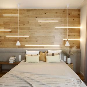 Jasne drewno za łóżkiem w sypialni w bloku. Projekt wnętrza i zdjęcie: Iwona Pietras, Miliform