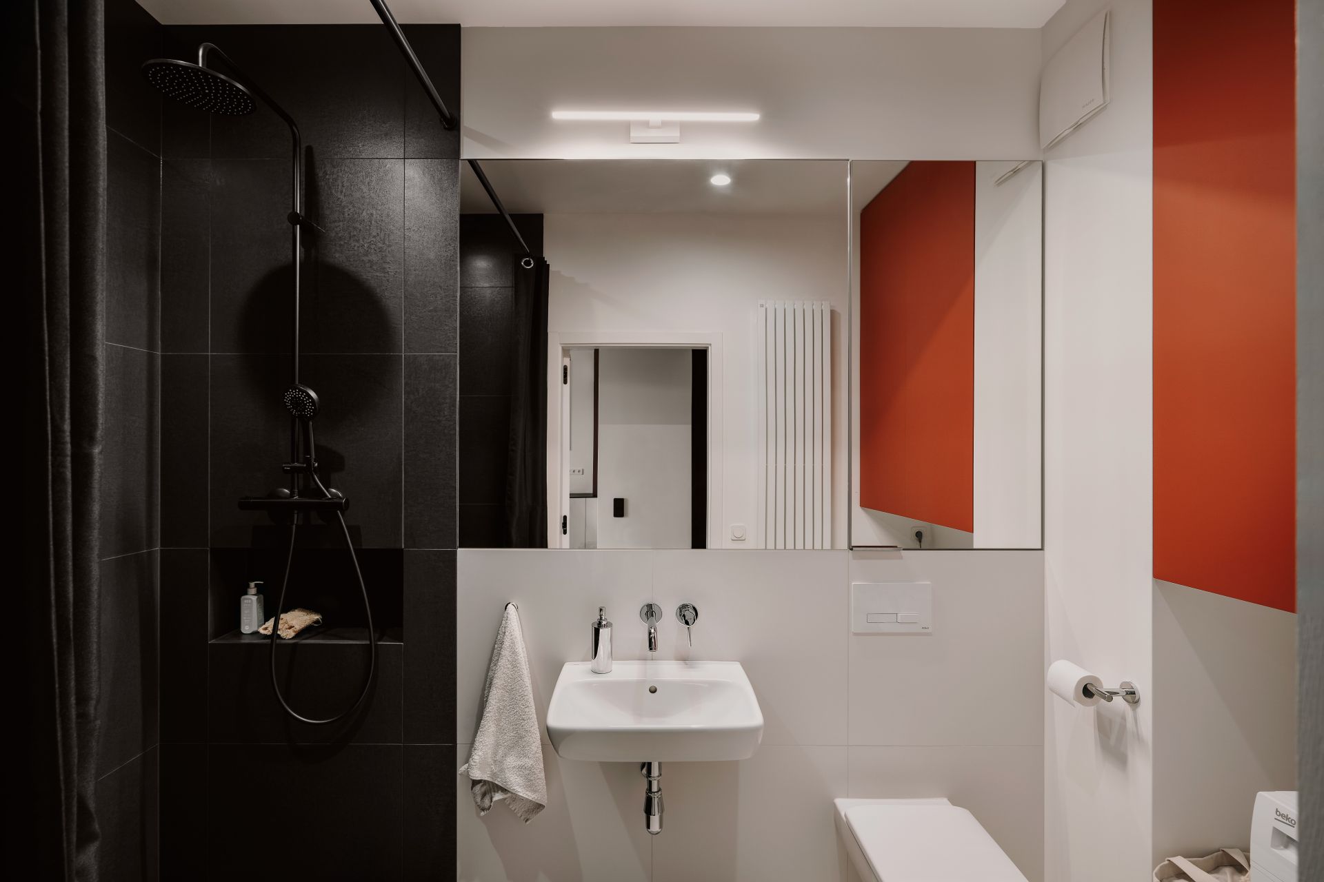 Łazienka w kolorach białym, czarnym i ceglastym. Projekt wnętrza: WAM studio projektowe. Zdjęcia: Migdał Studio
