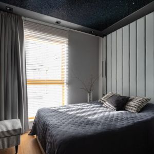 Szary, tapicerowany zagłówek na ścianie za łóżkiem w nowoczesnej sypialni. Projekt wnętrza: Iliana Olech. Fot. Natalia Kaczmarek, Inkadr