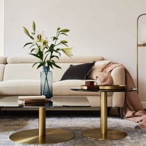 Beżowa sofa i złote stoliki kawowe w salonie. Projekt: Hanna Pietras Architects, Joanna Grzybowska. Fot. i stylizacja: Follow The Flow Studio
