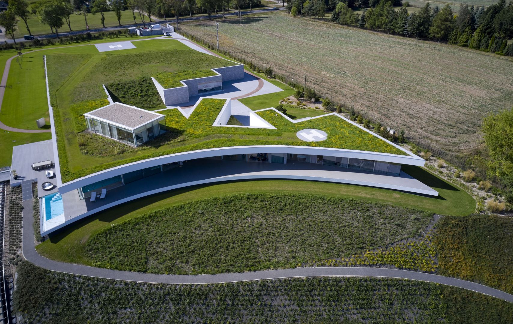 Bryła rozległego domu nabrała formy fałdy terenu wpisanej w spadek zbocza i przypominając nadmorską wydmę. Projekt: Przemek Olczyk, Mobius Architekci. Fot. Paweł Ulatowski