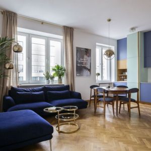 Niebieska kanapa i niebieskie meble w salonie w bloku. Projekt wnętrza: in architekci, Anna Białobrzewska. Fot. Hanna Połczyńska, Kroniki Studio