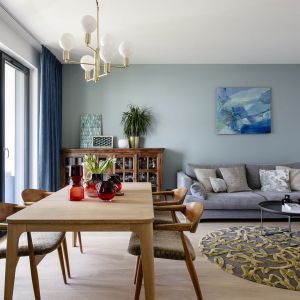 Szara kanapa i niebieska ściana w nowoczesnym salonie. Projekt wnętrza: Magdalena Bielicka, Maria Zrzelska-Pawlak, pracownia Magma. Fot. Kroniki Studio