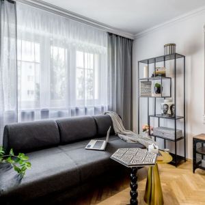 38-metrowe mieszkanie. Szara kanapa i tapeta na ścianie w małym salonie. Projekt wnętrza: Marta Piórkowska-Paluch. Fot. Andrzej Czechowicz, Foto Studio Wrzosy