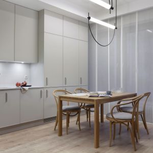W kuchni połączonej z jadalnią i salonem króluje kolor biały. Projekt wnętrza i zdjęcie: KODO Projekty i Realizacje Wnętrz