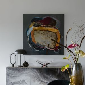 Forma stołu wykonana z tłoczonej blachy nawiązuje do wielu dzieł sztuki obecnych w domu. Projekt wnętrza: Marta Drzymała Mum Studio. Stylizacja: Agnieszka Możdżer. Fot. Yassen Hristov