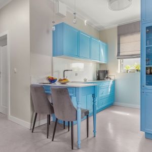 Szkło na ścianie nad blatem w kuchni i niebieskie meble. Projekt wnętrza: Beata Ignasiak, pracownia Ignasiak Interiors. Fot. Grupa Deix
