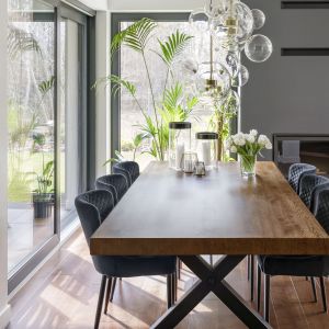 Ciekaw konstrukcja stołu może pomieścić aż osiem osób na wygodnych, tapicerowanych siedziskach. Projekt wnętrza: pracownia Miśkiewicz Design. Fot. Łukasz Zandecki