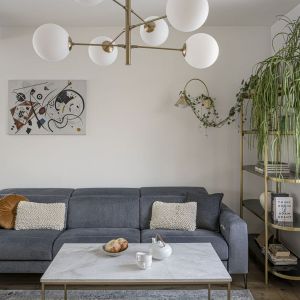 Grafitowa kanapa zajmuje główne miejsce w salonie. Projekt wnętrza:  Agnieszka Musiał-Chmielnik, Musiał Studio. Fot. Łukasz Zandecki