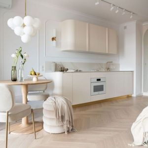 Mieszkanie o powierzchni 27 m² z małą kuchnią w jasnych kolorach. Projekt wnętrza: Sobkowiak Architektura. Fot. Wiktoria Wasiak. Stylizacja: Agata Sobkowiak / Sobkowiak Architektura
