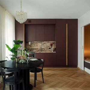 Mieszkanie o powierzchni 30 m²: marmur na ścianie nad blatem w małej kuchni. Projekt wnętrza: Jacek Kamiński. Fot. Jakub Nicieja