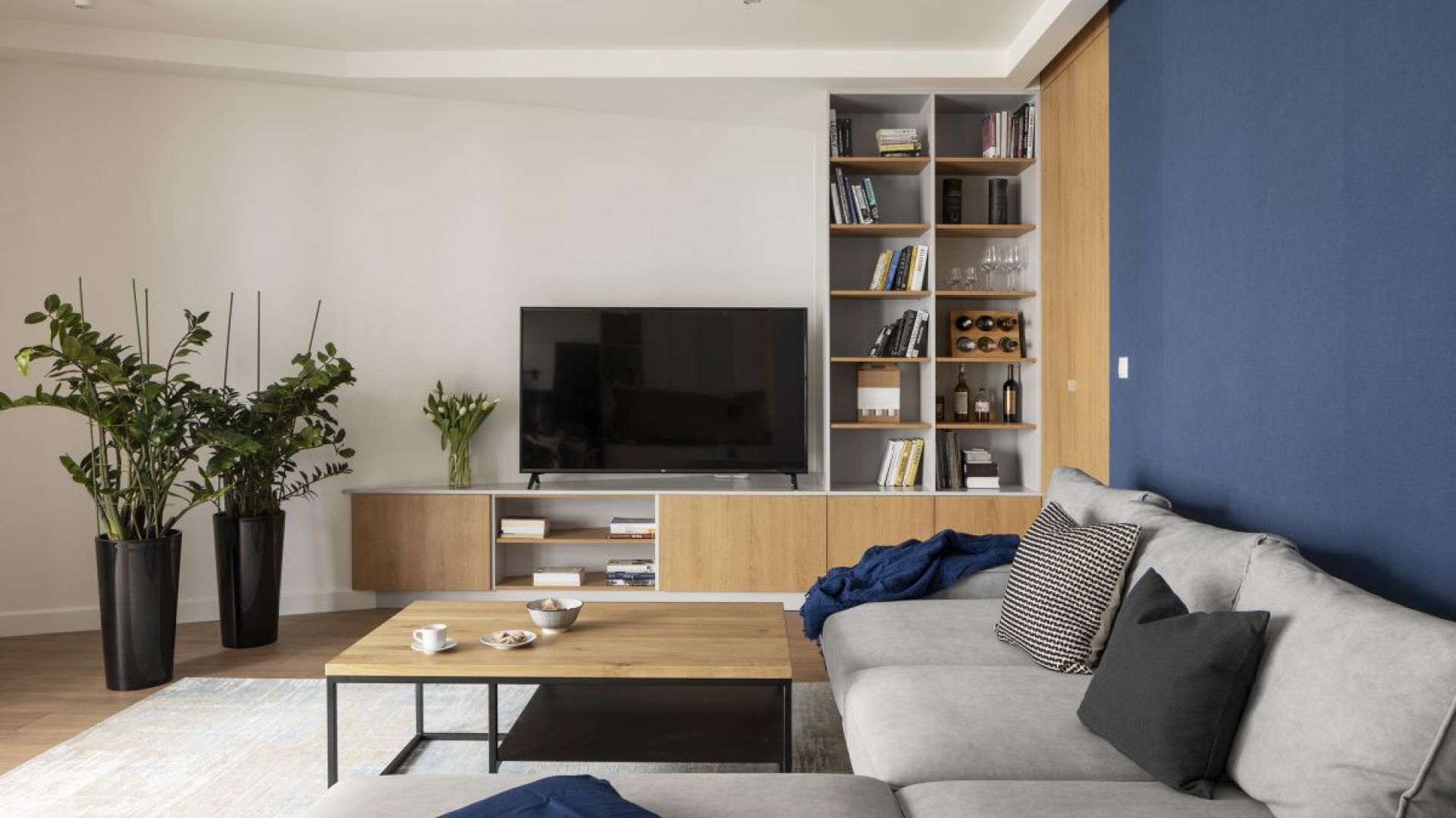 70-metrowe mieszkanie: biała kuchnia i jasny salon z drewnem