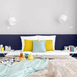 Szare ściany i niebieskie łóżko w małej sypialni. Projekt wnętrza: Decoroom. Fot. Marta Behling / Pion Poziom