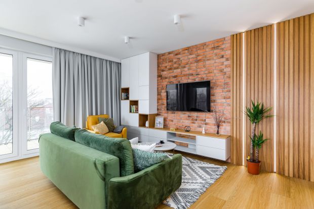 65-metrowe mieszkanie w Warszawie. Zielona kanapa, białe meble. Wygodne wnętrze!