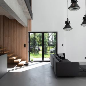 W salonie dominują drewniane i betonowe elementy, które dodają wnętrzu elegancji i surowego charakteru. Projekt wnętrza: mode:lina™. Fot. Patryk Lewiński