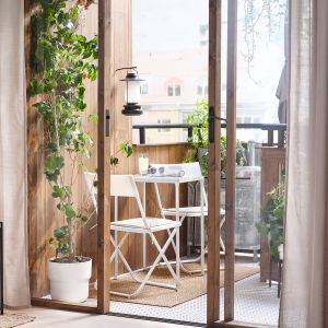 Mały miejski balkon - dywan balkonowy, białe składane meble - stolik i krzesełka. Wszystkie  meble i dekoracje: IKEA