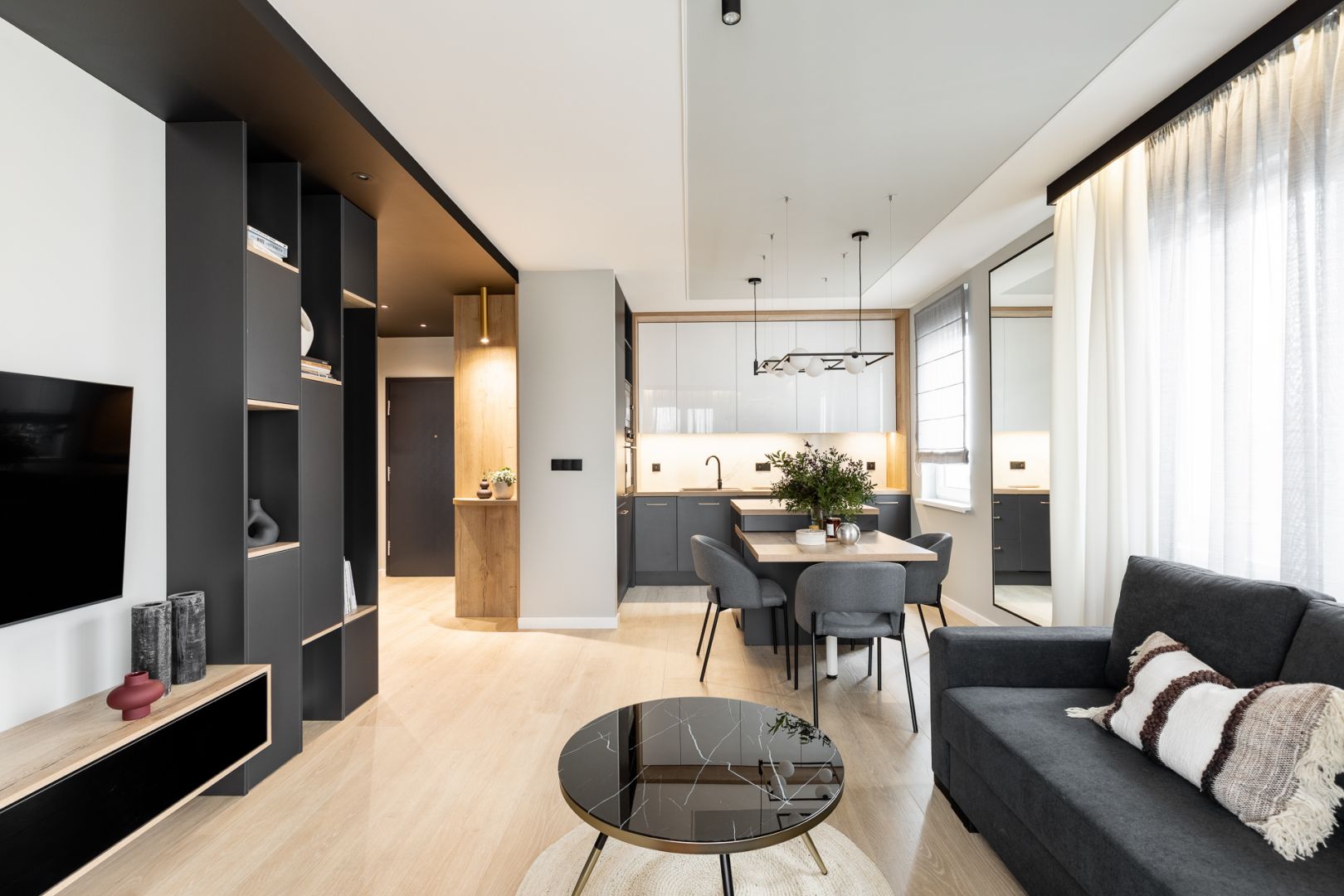 Salon z aneksem kuchennym tworzą jedną, spójną całość. Projekt wnętrza: Paweł Ślęzak, pracownia Architaste. Fot. Dominika Wilk