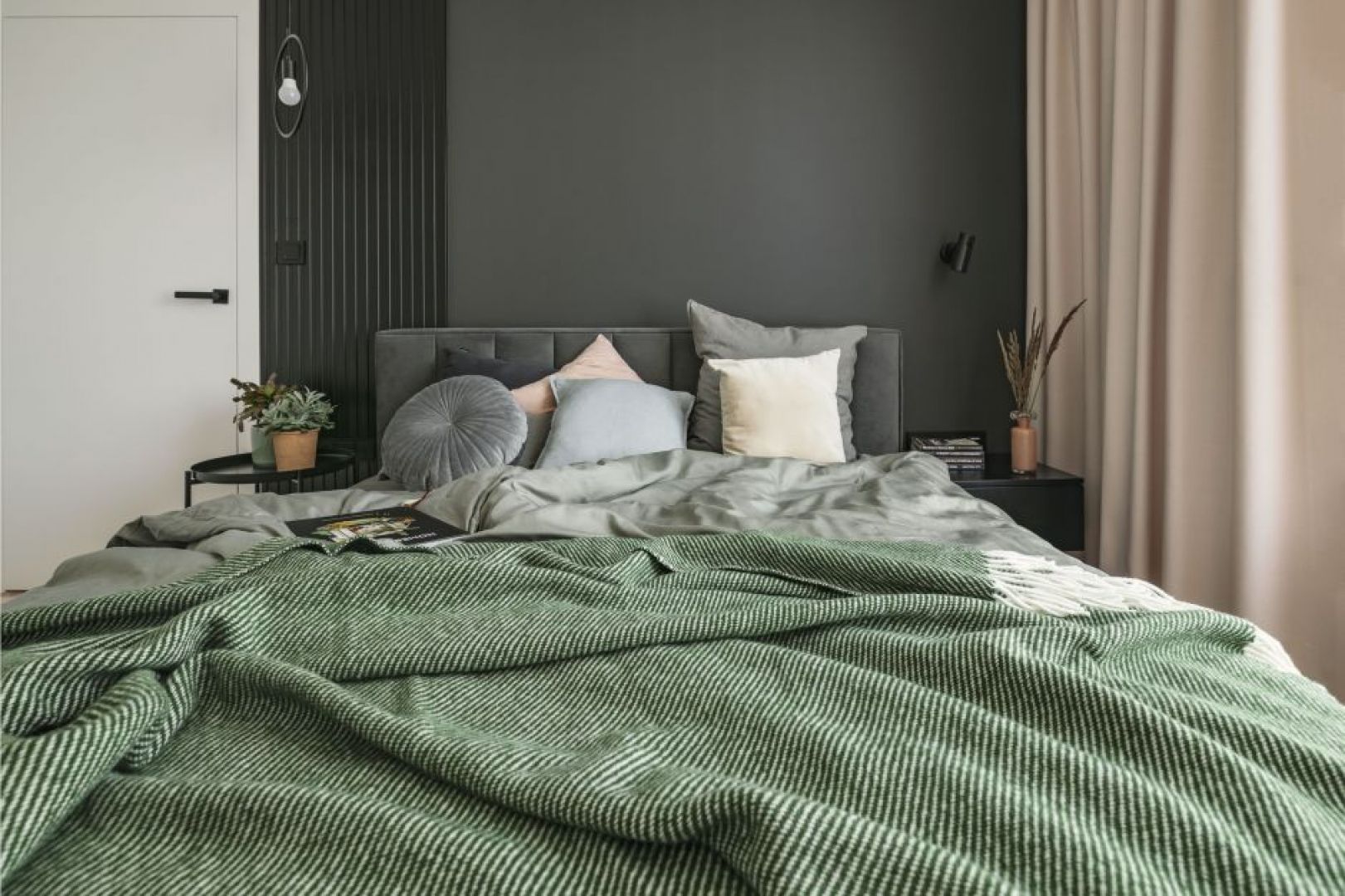 Farba w czarnym kolorze na ścianie za łóżkiem w sypialni. Projekt wnętrza: PRW Design. Fot. Kamila Markiewicz-Lubańska. Stylizacja: Maria Bartoszewska
