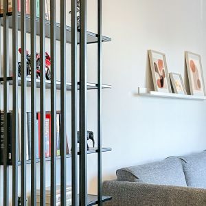 Czarne spawane profile przysłaniają widok z przedsionka na salon. Projekt wnętrza: Adam Jankowski, Kamil Paszek, AMJ studio. Fot. AMJ studio