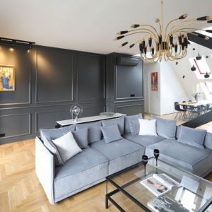Elegancki salon: lamperie i kamień na ścianie, drewniana podłoga. Projekt wnętrza: Katarzyna Mikulska-Sękalska. Fot. Bartosz Jarosz