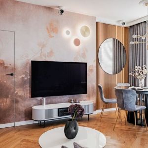 Przytulny salon: tapeta i lamele na ścianie, drewno na podłodze. Projekt wnętrza: Maja Śmichura, Deer Design. Fot. Zagórny Studio