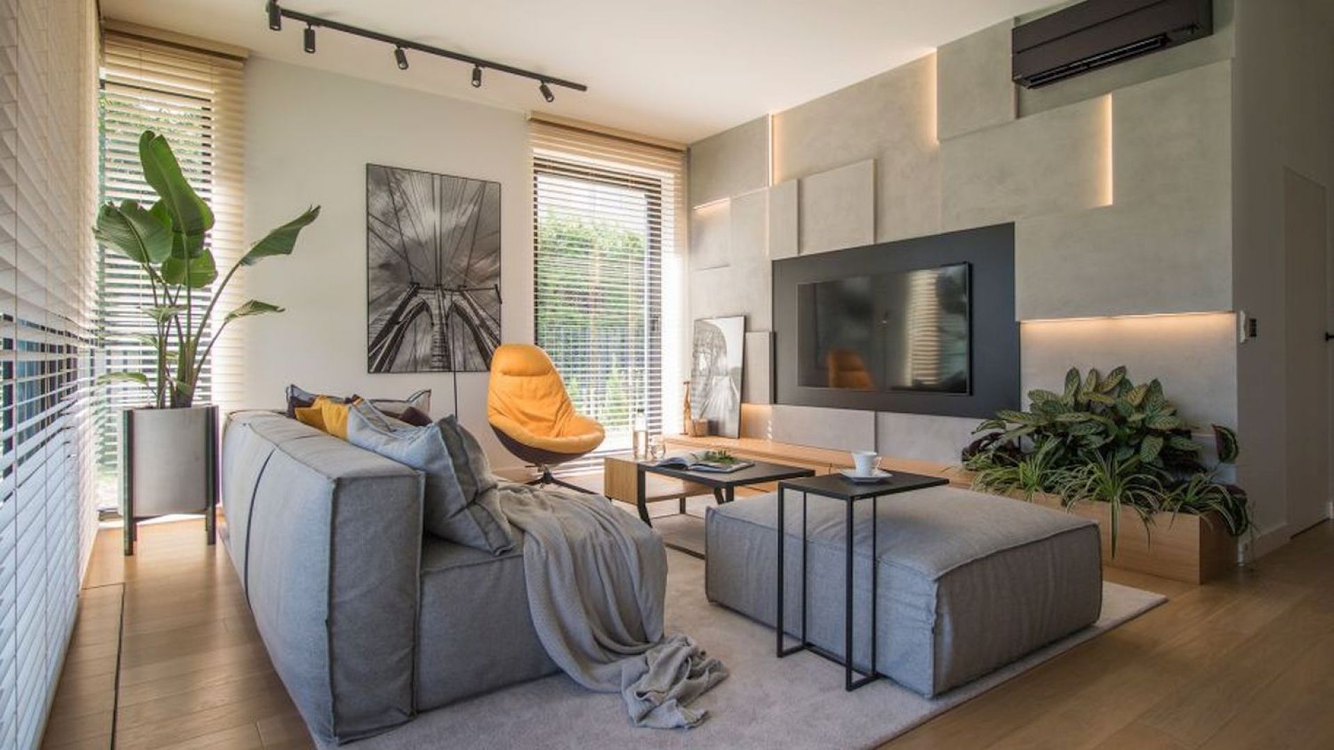 Salon w bloku: beton na ścianie, jasne drewno na podłodze. Projekt wnętrza: Natalia Teixeira, Kasia Beresińska, pracownia TK Architekci. Fot. TK Architekci