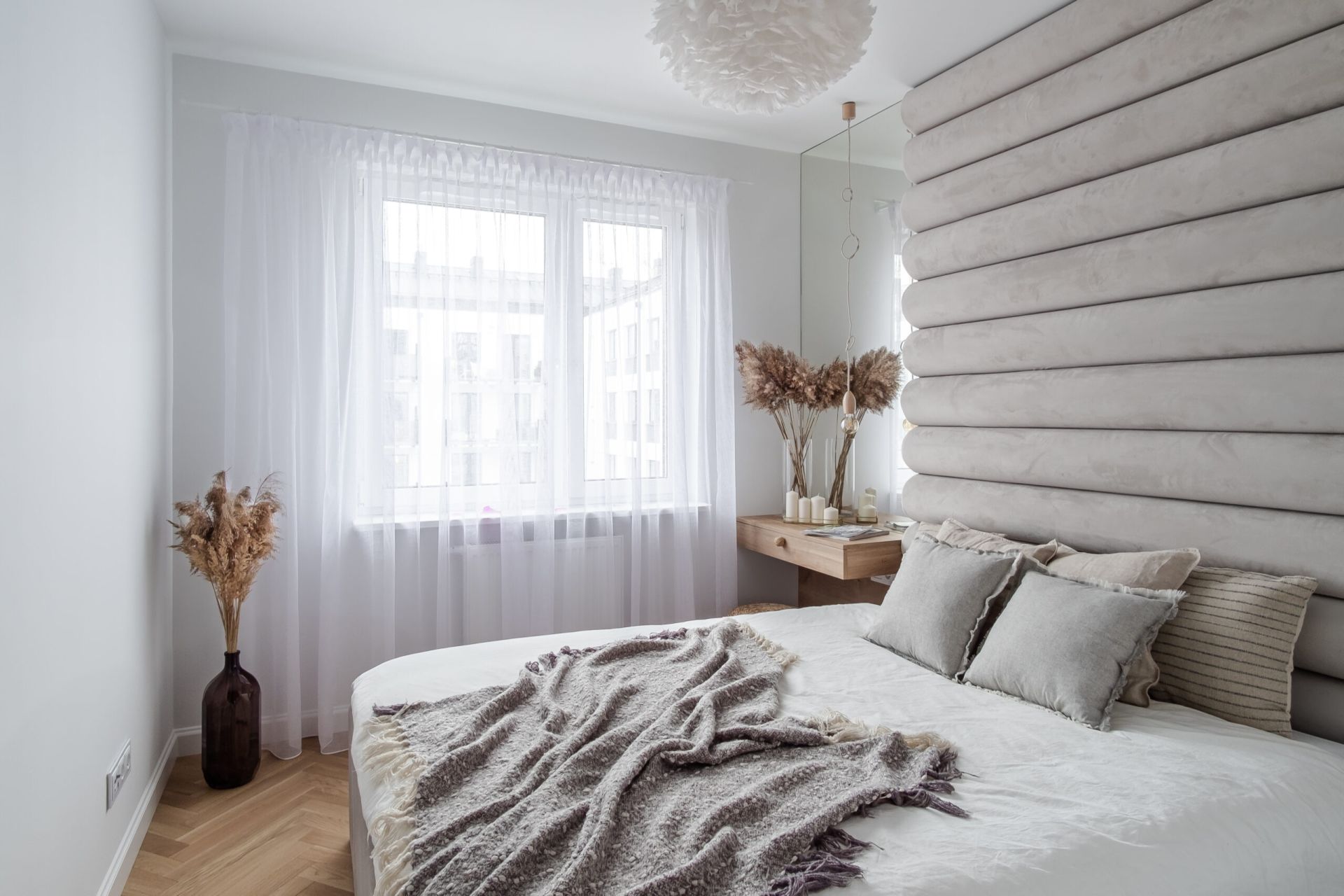 Elegancka beżowa sypialnia z tapicerowaną ścianą. Projekt wnętrza latreDesign. Fot. Bernadetta Kuczyńska