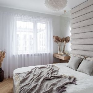 Elegancka beżowa sypialnia z tapicerowaną ścianą. Projekt wnętrza latreDesign. Fot. Bernadetta Kuczyńska