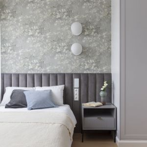 Jasna tapeta na ścianie za łóżkiem i szara szafa w sypialni. Projekt wnętrza: One Design. Fot. Pion Poziom
