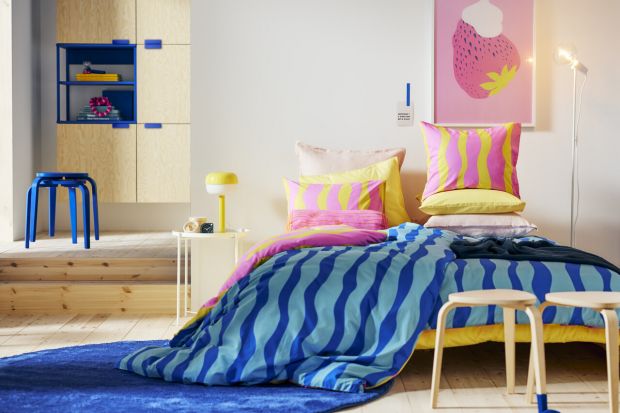 Nowoczesna sofa, kolorowy dywan, kobaltowy stołek, żółty stołek, zabawne poduszki. Zobacz rozmaite nowości od Ikea. <br /><br /><br />