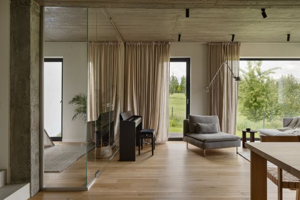 Właściciele tego nowoczesnego domu są fanami minimalizmu. Nie mogło więc tu zabraknąć mikrocementu, betonu i szarości. Wszystko ociepla jednak eleganckie  i ponadczasowe drewno. Piękny projekt domu!
